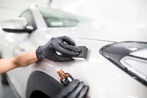 Car detailing - Man applies nano protective coating to the car