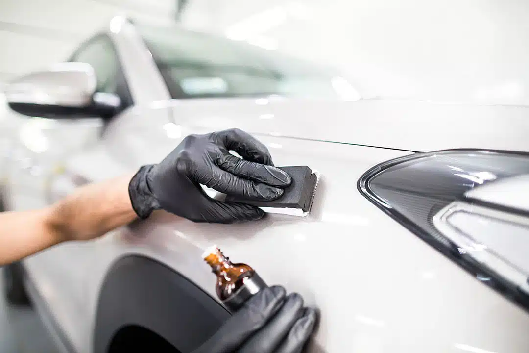 Car detailing - Man applies nano protective coating to the car
